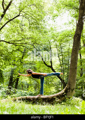La donna a praticare lo Yoga nel bosco Foto Stock