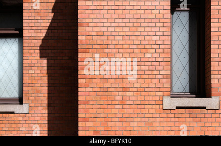 Rosso la parete in mattoni con windows Foto Stock