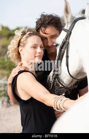 Coppia sorridente holding cavallo Foto Stock