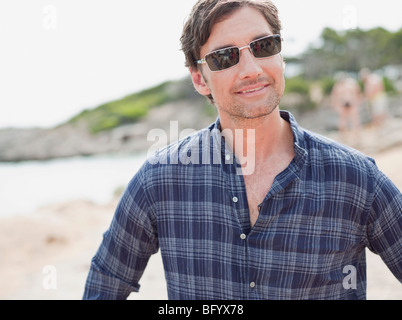 Uomo con occhiali da sole sorridente al viewer Foto Stock