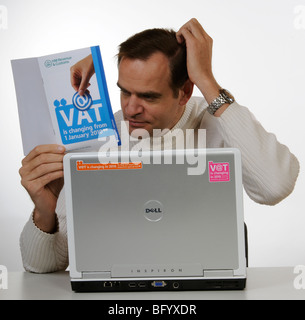 Iva cambiamenti per il 2010 uomo studiando HM Revenue & Customs Information booklet Foto Stock