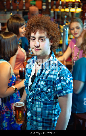 Giovane uomo tenendo un bicchiere di birra Foto Stock