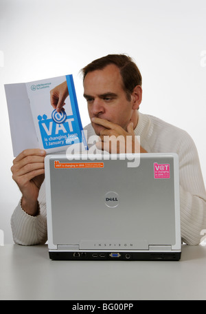 Iva cambiamenti per il 2010 uomo studiando HM Revenue & Customs Information booklet Foto Stock