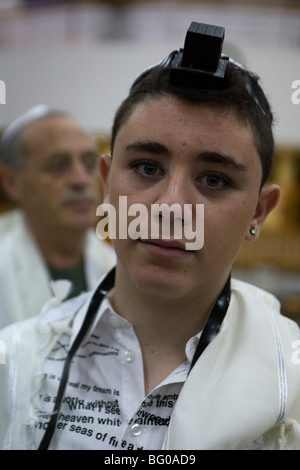 Bar Mitzvà boy recante tefillin (filatteri) durante la cerimonia Foto Stock