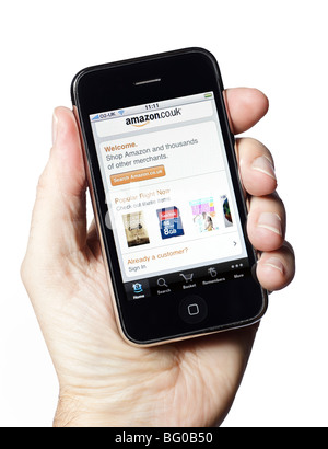 Maschio lato tiene iPhone mostra Amazon shopping online applicazione Foto Stock