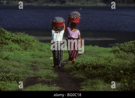 Due donne prendono i vestiti al lago Atitlan per lavaggio vicino a San Pedro, Guatemala Foto Stock