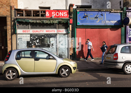 Negozi abbandonati e moderne auto urbana, Credit Crunch, pavimentazione, Clapham, London, Regno Unito Foto Stock