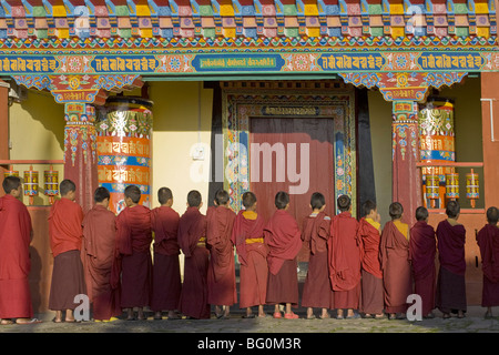 Il debuttante linea monaci fino di fronte all edificio monastico presso il nuovo Karma Theckhling Monastero, Ravangla (Rabongla), il Sikkim, India Foto Stock