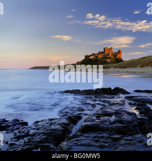 Il castello di Bamburgh inondata dalla calda luce della sera, Bamburgh, Northumberland, England, Regno Unito, Europa Foto Stock