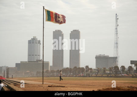 La bandiera dello Sri Lanka vola sopra Galle Face Green in Colombo. Lo Sri Lanka. Gli edifici del quartiere centrale degli affari può essere visto Foto Stock