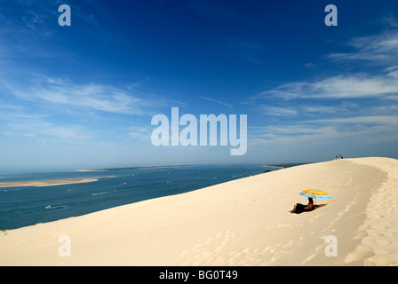 Turisti sotto un ombrellone sulle Dune du Pyla, dune di sabbia più grande in Europa, la baia di Arcachon, Cote d'Argent, Gironde, Aquitaine, Francia Foto Stock
