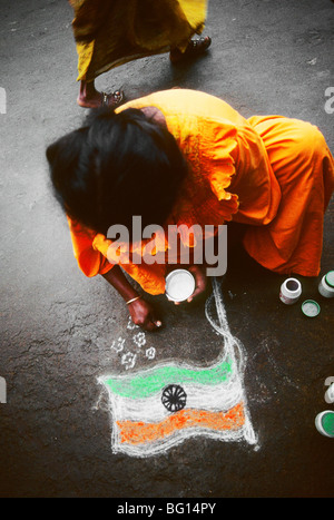 Una donna fa un chalk disegno della bandiera indiana in Palani, India indiano sul Giorno di Indipendenza (15 agosto), che commemora l'India?s indipendenza dalla dominazione britannica e la sua nascita come Nazione sovrana nel 1947. Foto Stock