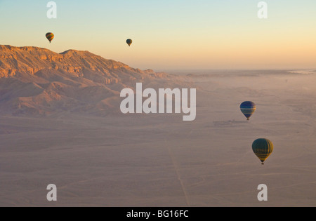 I palloni ad aria calda volando sul deserto all'alba sulla sponda ovest del Nilo vicino a Luxor, Egitto, Nord Africa Foto Stock