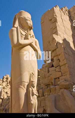 Statua di Ramses II e la figlia piegate'anta tra le sue gambe dietro il pilone del grande tempio di Karnak nrr Luxor, Tebe, Egitto Foto Stock