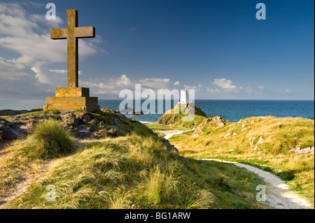 Stone Cross e il faro di Twr Mawr sull'isola di Llanddwyn, vicino a Newborough, Anglesey, Galles del Nord, Regno Unito Foto Stock