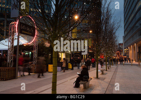 Regno Unito, Inghilterra, Manchester, Spinningfields durante la notte, i visitatori al di fuori di Natale pista di pattinaggio su ghiaccio Foto Stock