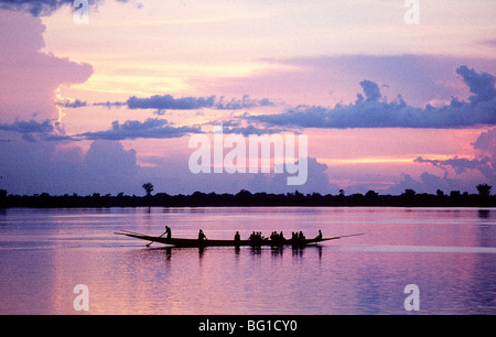 Una piroga, una piroga con un fondo piatto sono stati utilizzati per la pesca e il trasporto lungo il fiume Niger sin dai tempi antichi è solo circa il pieno con persone rubrica a monte sul fiume, Mali, Africa occidentale Foto Stock