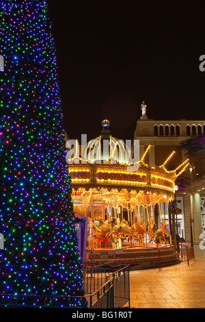 Regno Unito, Inghilterra, Manchester, il Trafford Centre shopping mall, Barton Square, tradizionale giostra e un albero di Natale Foto Stock