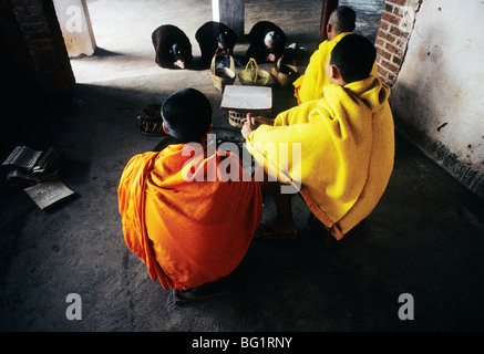 Tre donne prua di monaci buddisti in Menghai, nella provincia dello Yunnan in Cina prima di entrare il loro tempio Foto Stock