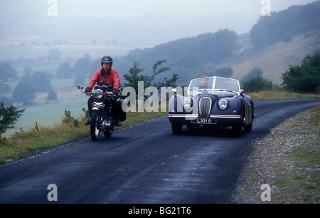 Anni Cinquanta la Jaguar XK120 e Vincent ombra nera motociclo in un paese di lingua inglese road nel Derbyshire. Foto Stock