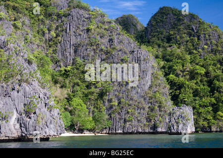 Banul Beach, una piccola spiaggia che tagliato in una piega nella scogliera, a Coron isola nel Sud delle Filippine. Foto Stock