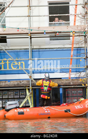 RNLI e mountain rescue team evacuare i residenti da Cockermouths strada principale durante la devastante Novembre 2009 inondazioni. Foto Stock