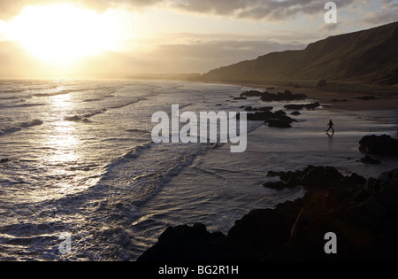 Il camminatore solitario sulla splendida spiaggia sabbiosa di San Ciro, Aberdeenshire, Scozia, al tramonto Foto Stock