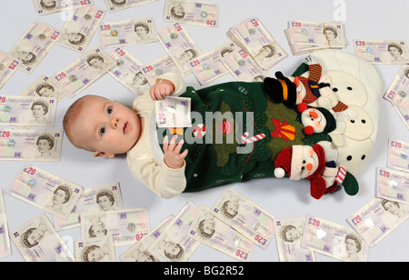 Baby boy in calza di Natale con un sacco di soldi regno unito Foto Stock