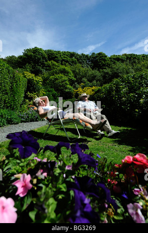 I PENSIONATI godendo il pensionamento dormire a prendere il sole nel giardino Inglese UK Foto Stock