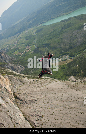 BASE jump da una scogliera. La ultimate kick per fare un salto in oggetto con una wingsuit su volare e di prossimità lungo la montagna. Foto Stock