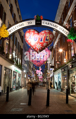 Shopping di Natale lungo alla moda di Carnaby Street Foto Stock