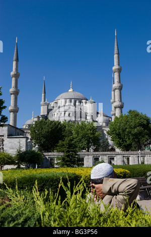 Bagno turco uomo con tradizionale headware rilassante in Piazza Sultanahmet di fronte alla Moschea Blu, Istanbul, Turchia, Europa Foto Stock