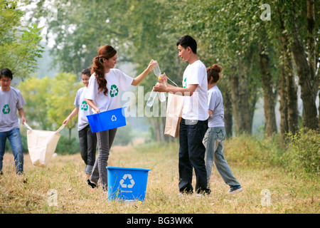 I giovani a raccogliere le bottiglie di plastica vuote per il riciclaggio Foto Stock