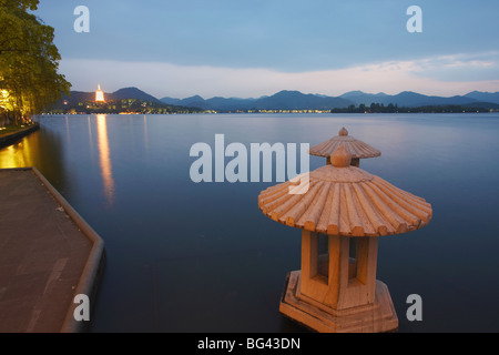 Xi Hu (West Lake) al tramonto con il Jinci Si Pagoda in background, Hangzhou, Zhejiang, Cina e Asia Foto Stock