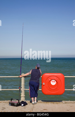 Inghilterra, East Sussex, Hastings, pescatore e canna da pesca Foto Stock