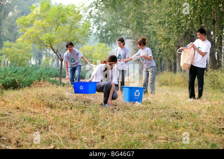 I giovani a raccogliere le bottiglie di plastica vuote per il riciclaggio Foto Stock