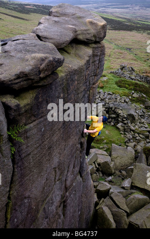 Scalatore crescente di uno delle migliaia di affioramenti di roccia, Stanage Edge, Peak District, Derbyshire, England, Regno Unito Foto Stock