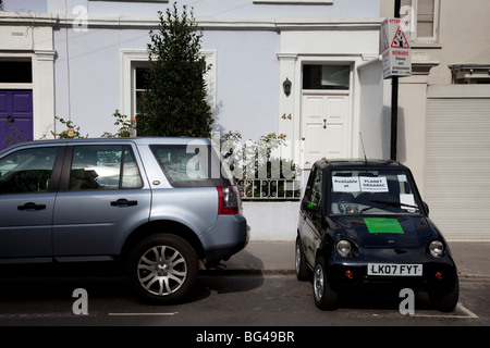 G-Wiz (AEV elettrica automatica) del veicolo parcheggiato di fianco. Il verde di soluzione di trasporto. Foto Stock