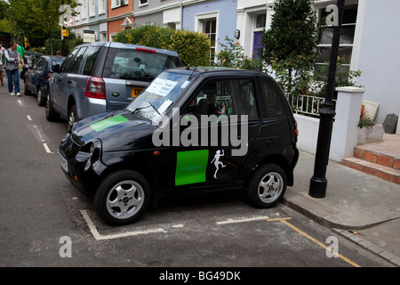 G-Wiz (AEV elettrica automatica) del veicolo parcheggiato di fianco. Il verde di soluzione di trasporto. Foto Stock