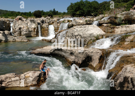 Due ragazzi che giocano nella cascata o Cascade di Sautadet sul fiume Cèze, la Roque sur Cèze, Gard, Languedoc Roussillon, Francia Foto Stock