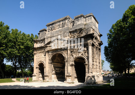 Coppia a piedi dall'Arco Romano di Trionfo o Arco Trionfale di Orange (c20BC), architettura classica Romana, Orange, Vaucluse, Provenza, Francia Foto Stock