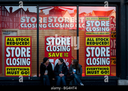 Negozio finestra segni la notifica della chiusura dello store in giù e stock liquidazione nel segno dei tempi Foto Stock