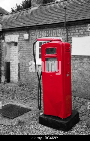 Raro, vecchia pompa di benzina sul lato strada di colore rosso a colori e in bianco e nero di sfondo Foto Stock