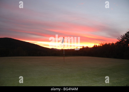 Sole sorge lungo le verdi montagne sopra un golf a Warren, Vermont, U.S.A. Foto Stock