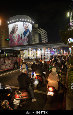 Moto in coda fino ad una luce rossa sul Zhongxiao Rd all'intersezione di Fuxing Rd, Taipei, Taiwan, ROC Foto Stock