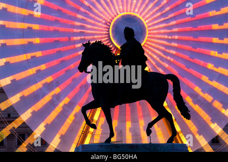 Statua di Luigi XIV durante la festa delle luci (ruota panoramica Ferris in background), Place Bellecour, Lione, Francia Foto Stock