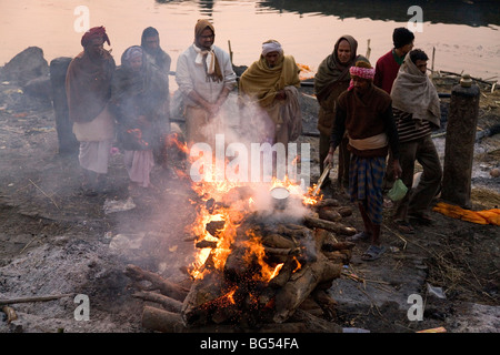 Una cremazione è effettuata sul Marnikarnika Ghat sulle rive del fiume Gange è Varanasi (India). Foto Stock