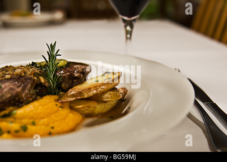 Carne e patate purea di zucca, servita con vino rosso. Foto Stock