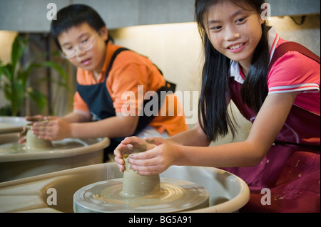 Due giovani bambini che prendono parte a una ruota-gettando classe. Foto Stock