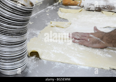 Panificio industriale. Baker e per impastare la pasta di appiattimento Foto Stock